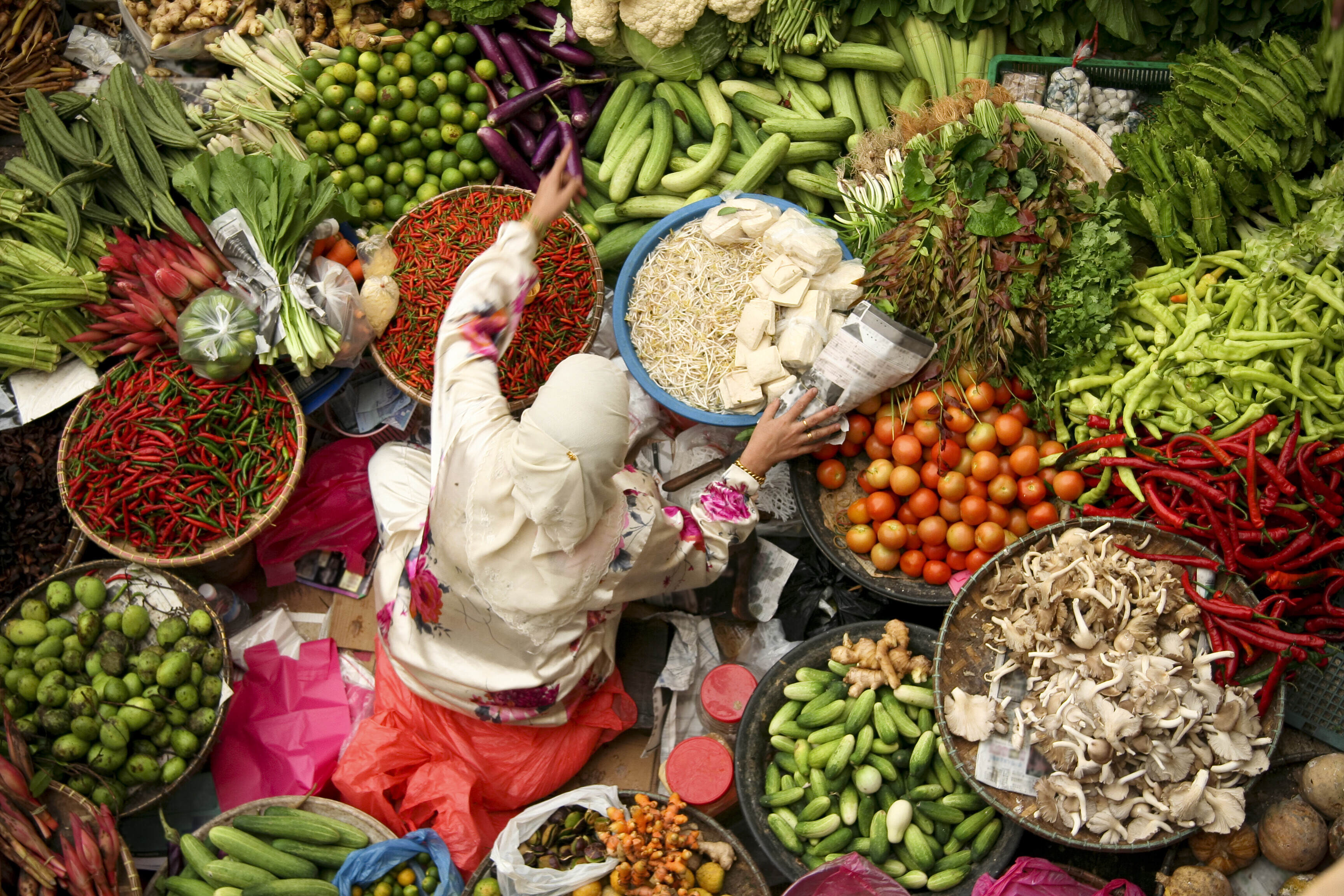 A woman selling fresh vegetables at market in Kota Baru, Malaysia